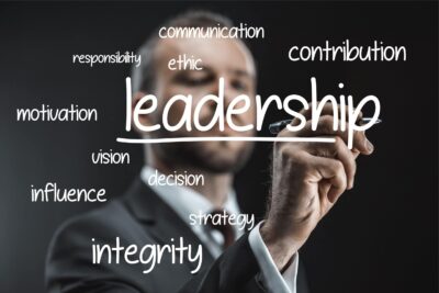 A man writing the word leadership on a blackboard.