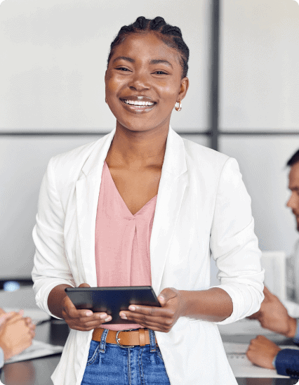 A woman holding a tablet in front of a group of people.